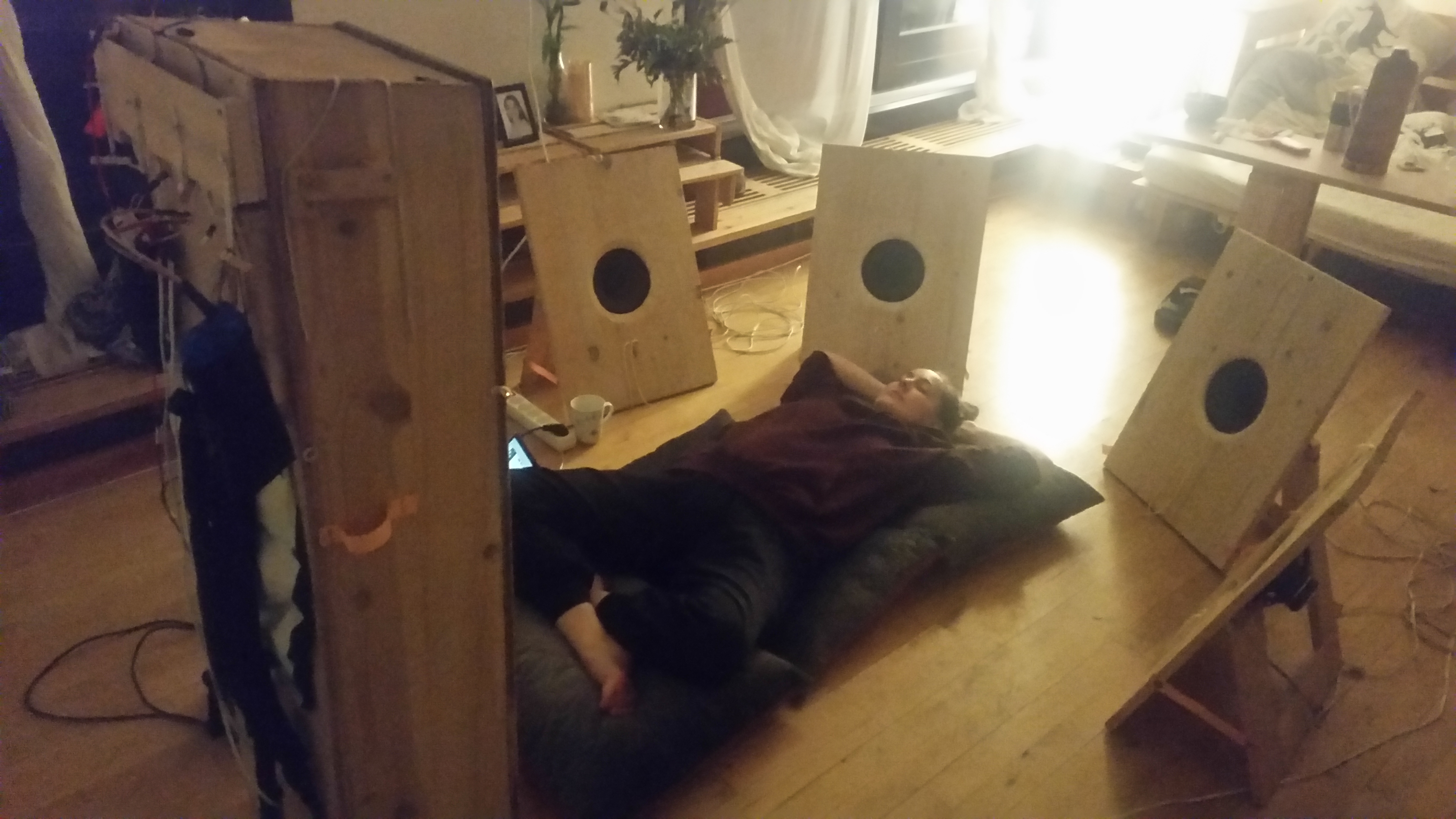 Højtalere i en cirkel omkring liggende person